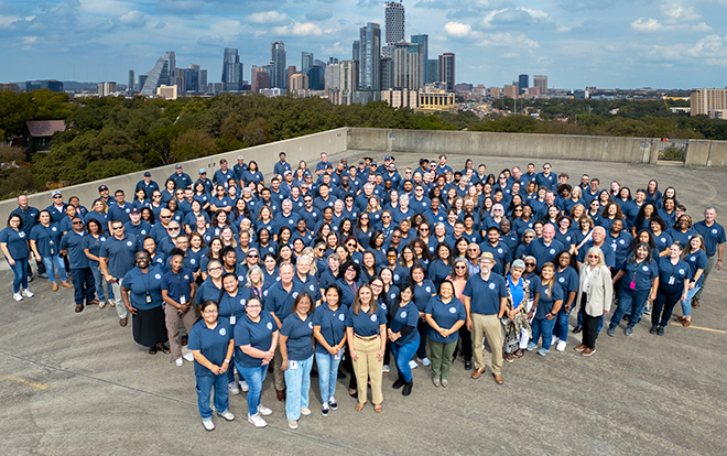 Photo of Austin Housing Employees with Austin skyline in background