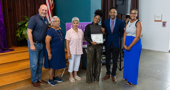 Photo of family with graduate holding certificate.