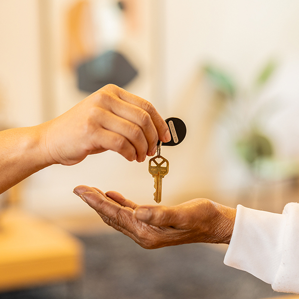 Photo of a key held over a person's hand.