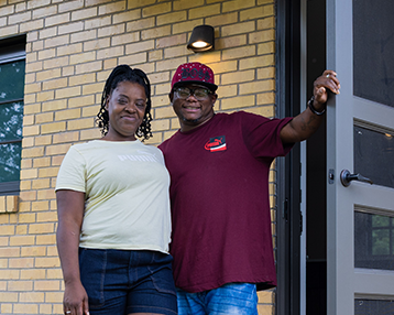 Photo of man and woman standing by front door.
