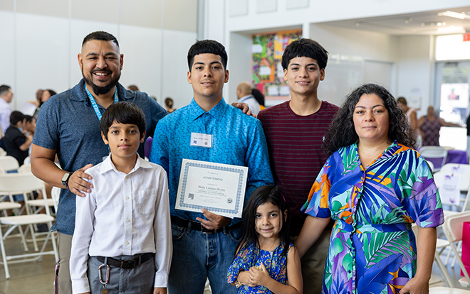 Photo of family at ceremony holding diploma.