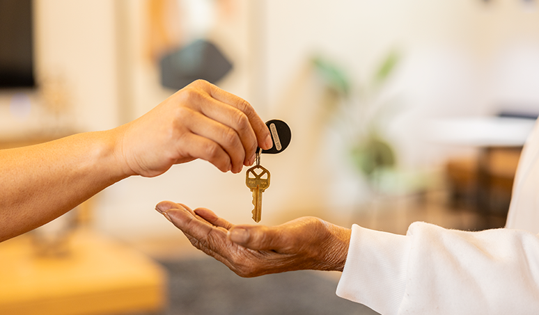 Photo of keys being handed to another person.