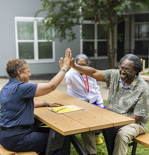 Photo of two people giving high fives.